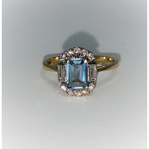366 - An 18 carat gold dress ring set emerald cut aquamarine flanked by 2 baguette cut and 10 small brilli... 