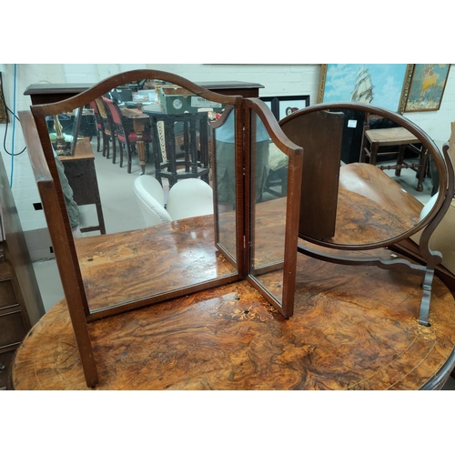 601 - An oval mirror in free-standing mahogany frame; a similar triple mirror