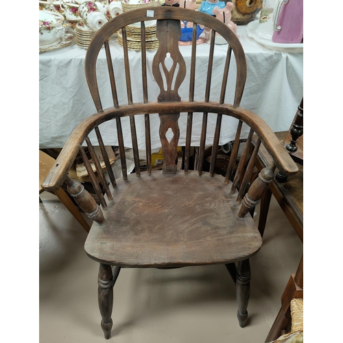 604 - A 19th century elm Windsor armchair with low back and pierced splat, on turned legs