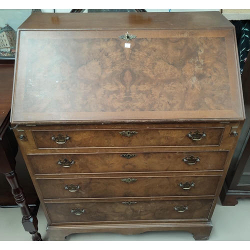 605 - A reproduction fall front bureau in crossbanded burr walnut, with fitted interior and 4 drawers