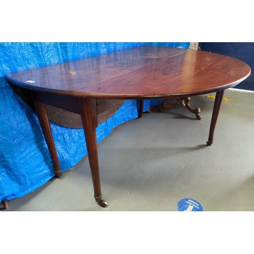 557A - A Georgian mahogany dining table with oval drop leaf top, on turned legs and castors, 140 cm