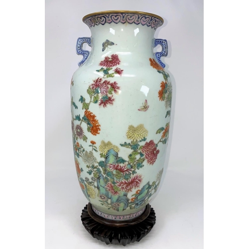 104 - A Chinese vase decorated with detailed flowers and insects, flared rim and 2 handles with character ... 