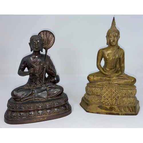 115 - An oriental bronzed Buddha figure in seated lotus position holding a leaf fan,  and a similar metal ... 