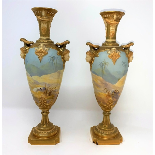 259 - A pair of Royal Worcester balluster vases with ornate gilt neck, facemask mounts decorated with cran... 