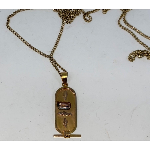 275a - A Middle Eastern pendant with raised Egyptian hieroglyph, unmarked, tests as circa 18 ct