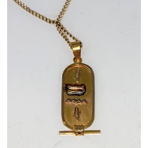 275a - A Middle Eastern pendant with raised Egyptian hieroglyph, unmarked, tests as circa 18 ct
