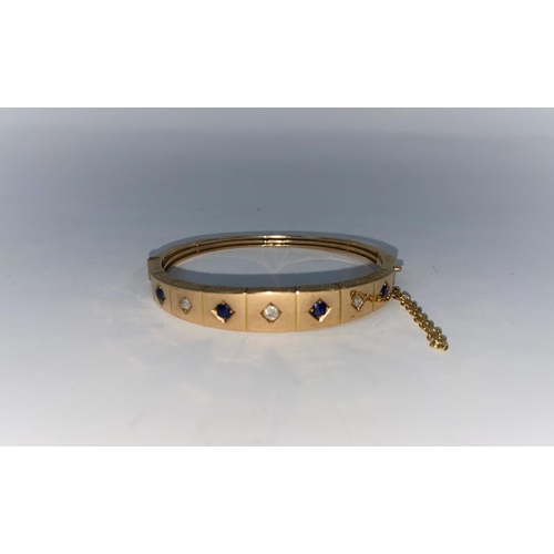 276a - An Edwardian hinged bangle set alternately with 4 diamonds and 3 sapphires, unmarked tests as 14 g a... 