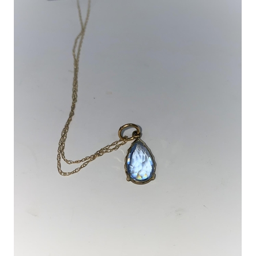 313F - A 14 carat gold pendant set with pale blue stone