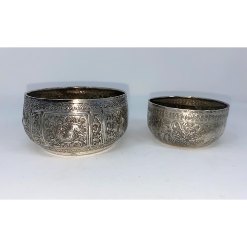 370 - Two Middle Eastern white metal bowls decorated in relief with elephants, snakes etc
