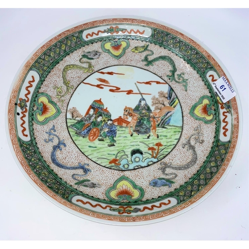 61 - A late 19th / early 20th century Kangxi style shallow dish decorated in polychrome with central pane... 