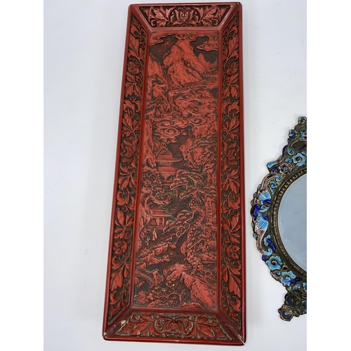 95 - A cloisonne framed Chinese mirror decorated with sea horses etc and a cinnabar coloured tray