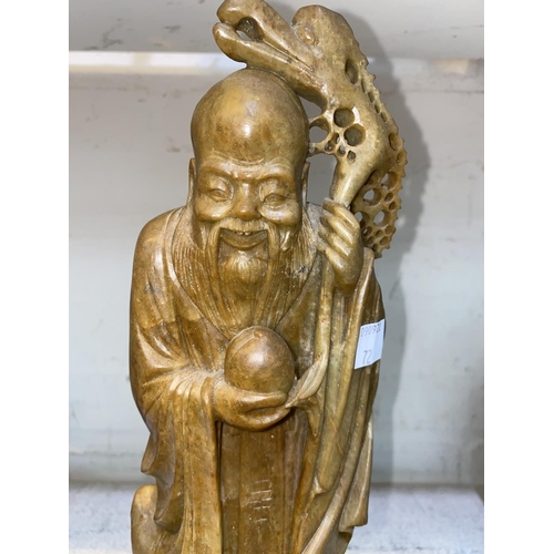 71 - A Chinese brown soapstone figure of a fisherman holding a rod and fish, height 35 cm; a similar grou... 