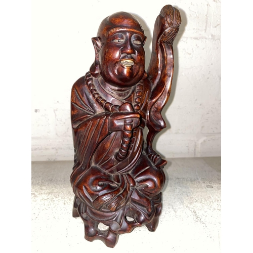 87 - A Chinese carved hardwood seated figure with beads and whisk height 27 cm
