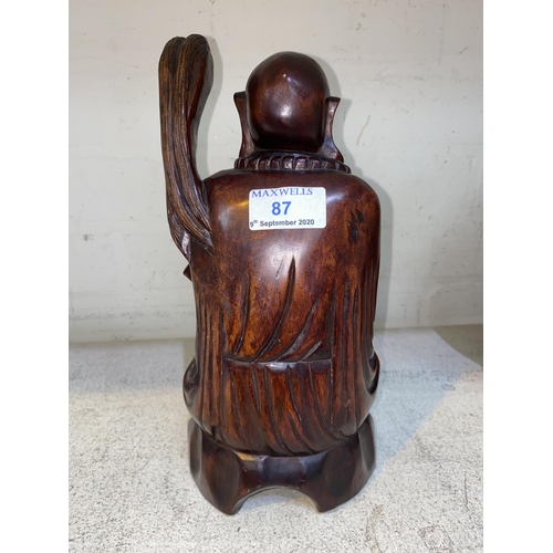 87 - A Chinese carved hardwood seated figure with beads and whisk height 27 cm
