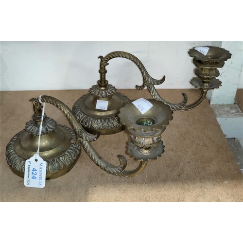 424 - An early 19th century pair of brass ornamental candle sconces for a grand piano, with weighted bases