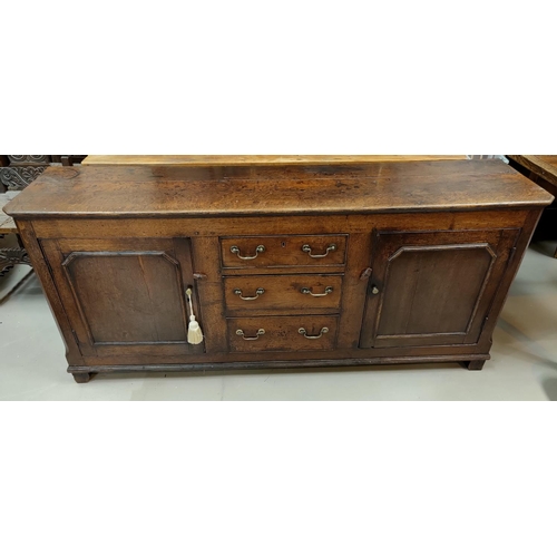 536 - An 18th Century countrymade oak dresser base with 2 panelled end cupboards and 3 central drawers wit... 