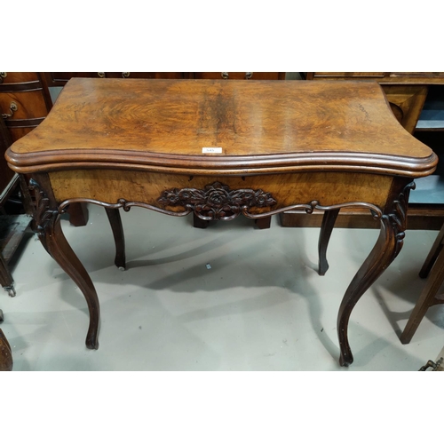 545 - A Victorian serpentine front burr walnut fold over baize lined card table with carved frieze and car... 