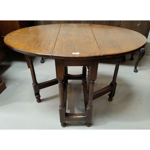 568 - An oak occasional/dining table with oval drop leaf top