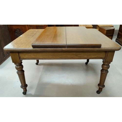 569 - A Victorian oak wind-out dining table on turned legs and castors, 2 leaves, extended length 78