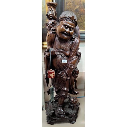 89 - A large Chinese carved wooden figure of a sage walking with a small animal. height 90cm