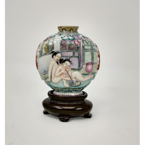 112 - A Chinese porcelain snuff bottle on stand, nude figures smoking to one side, characters to the other... 