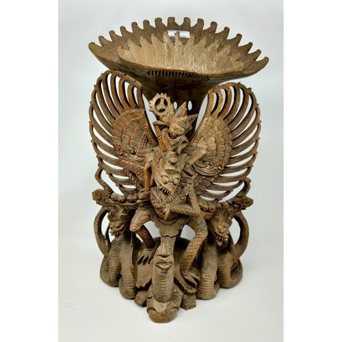 73 - An Indonesian large carved group:  winged figure on tortoise, height 51 cm