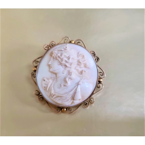 317 - A Victorian ivory circular brooch carved in relief with female bust profile, in yellow metal ornate ... 