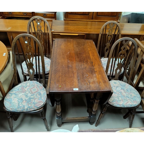 549 - Oval oak drop leaf dining table on turned legs and a set of 4 Windsor style dining chairs