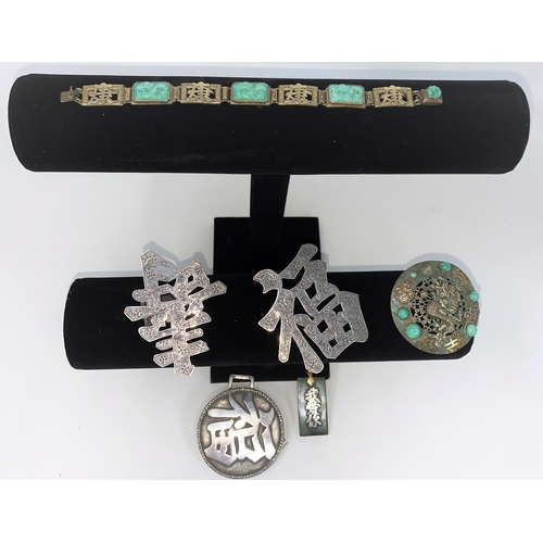 286 - An oriental style bracelet with alternating links of pierced symbols and jade coloured plaques carve... 