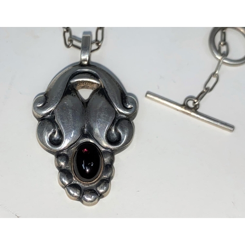 304 - Georg Jensen:  a silver pendant designed by Henning Koppel, set cabochon amethyst on silver link cha... 