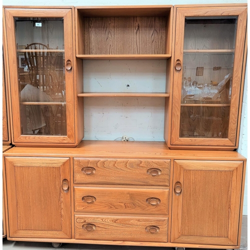 598 - An Ercol light elm full height sideboard, with 2 glazed cupboards and centre shelves over drawers an... 