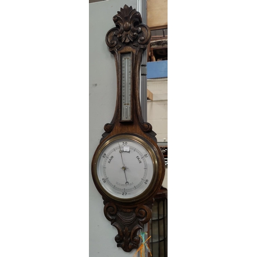 101 - An Edwardian aneroid barometer in carved oak case