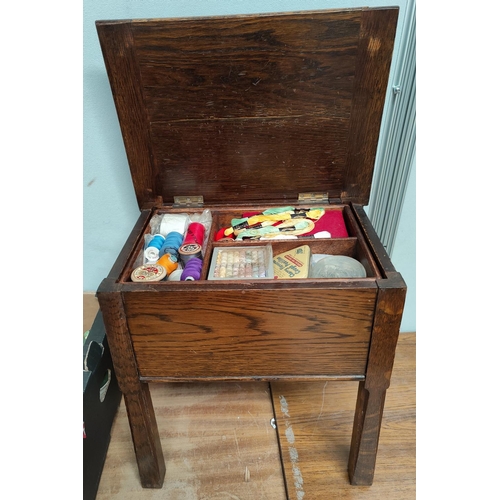 23 - An early 20th century oak workbox/stool and contents