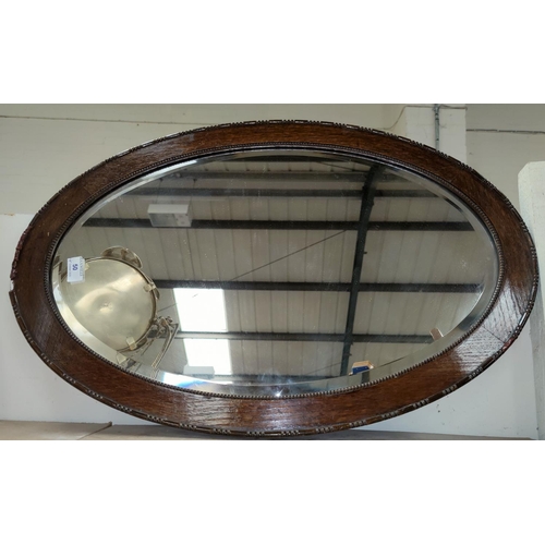 50 - An oval oak framed wall mirror and a selection of decorative glassware etc.