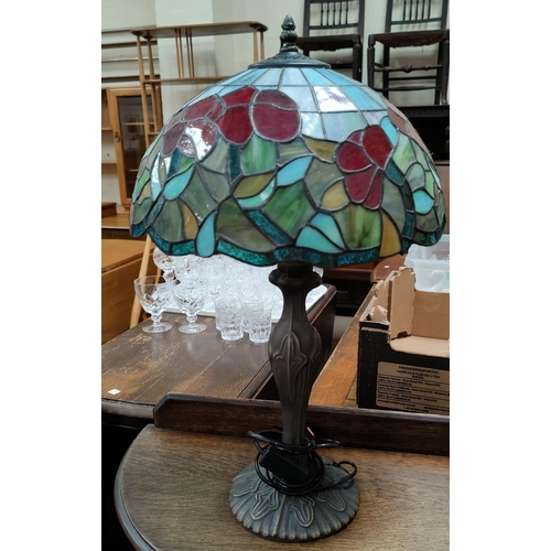 64 - A Tiffany style bronzed table lamp with leaded coloured glass shade