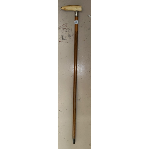 93 - An ivory handled and silver collared walking cane.