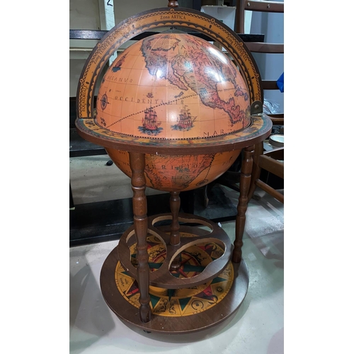 131A - A mid 20th century reproduction terrestrial globe drinks trolley with hinged lid and castors