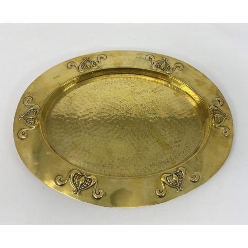 74A - An oval planished brass tray with embossed Art Nouveau relief decoration to the rim, stamped Baldry,... 