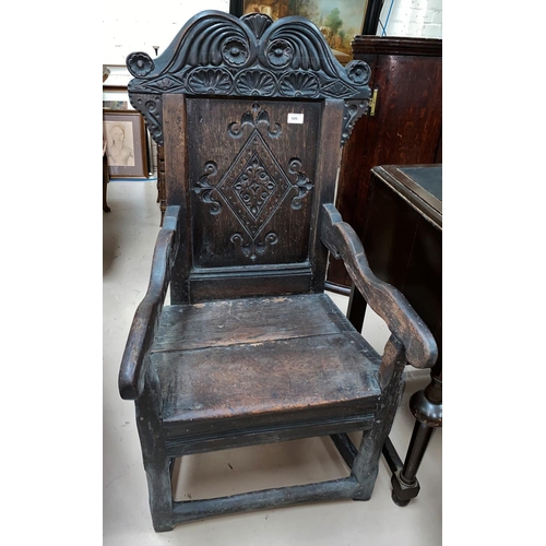 606 - An 18th Century oak Wainscott chair with panelled seat, carved decoration.