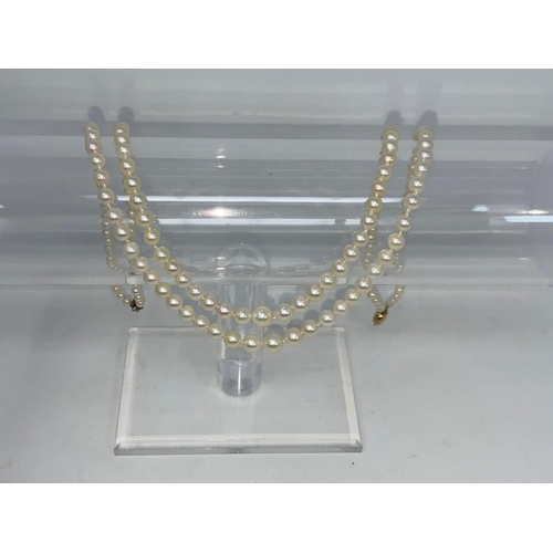 318 - A double strand cultured pearl necklace, the clasp stamped '375'