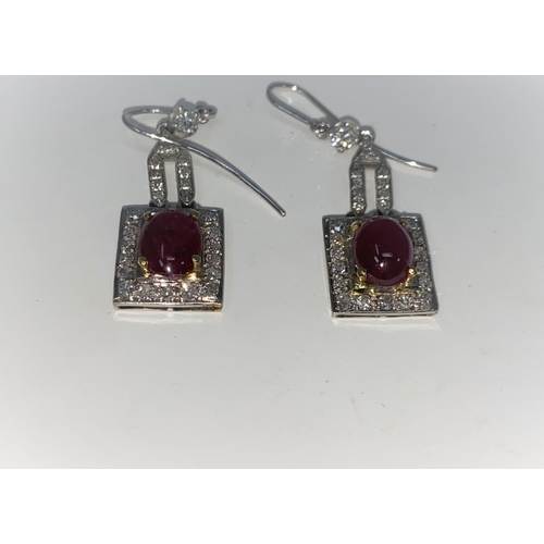 337 - A pair of Art Deco style white metal earrings, each set 28 diamonds and an oval cabochon ruby - test... 