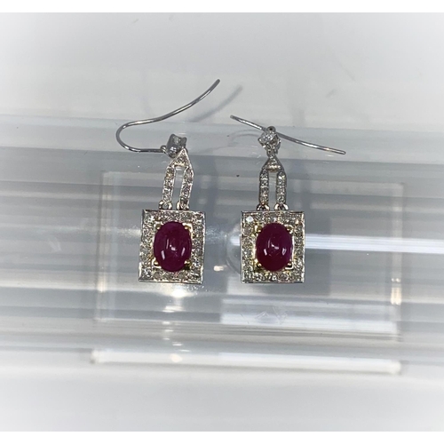 337 - A pair of Art Deco style white metal earrings, each set 28 diamonds and an oval cabochon ruby - test... 