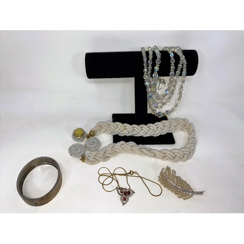 376 - An Edwardian gem set trefoil pendant on later unmarked chain; a silver hinged bangle, cased; a plait... 
