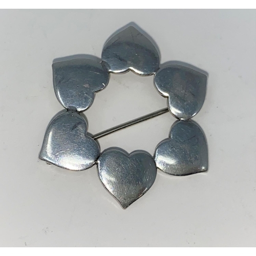 414 - A Danish silver brooch in the form of a circle of hearts. Marked on back: Danish Silver & makers sig... 