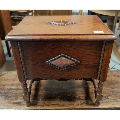 538 - An oak sewing box with beaded decoration, on bobbin legs