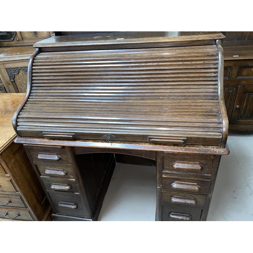 545 - An early 20th Century oak S-shaped roll top pedestal desk with fitted interior, eight drawers width ... 