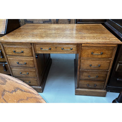 628 - A 1920's solid oak twin pedestal office desk fitted with 9 drawers with brass handles, 122 x 75cm hi... 