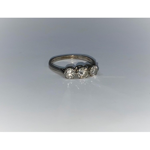 291 - A 3-stone diamond ring on white metal shank stamped 'platinum', the central diamond approximately .4... 