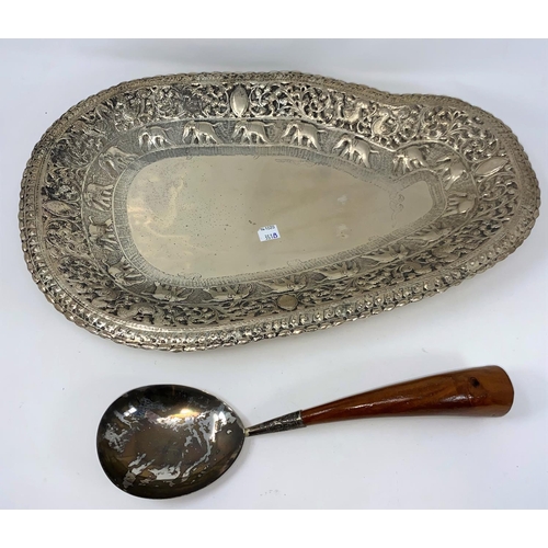 351B - An Indian silvered metal serving dish and spoon with extensive embossed decoration, inc elephants et... 