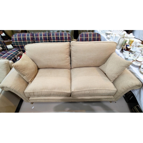 509 - A traditional 3 seater settee with scroll arms, on turned legs and castors, in striped gold fabric b... 